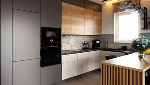 A modern kitchen with grey cabinets, a wooden island, and pendant lighting. - Lumina Apart near Pasaż Łódzki (Łódź)