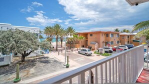 A hotel with a parking area, palm trees, and a clear blue sky. - Spectacular Ocean View Corner Apartment (Hollywood)