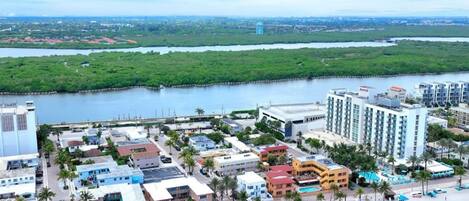 A coastal resort with beachfront villas, a swimming pool, and a beach with umbrellas.