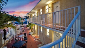 Un hôtel doté d’un balcon, de sièges en plein air et offrant une vue sur la rue.
