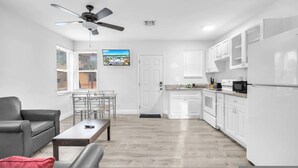 Un appartement moderne comprenant un coin repas, une cuisine et un ventilateur de plafond.