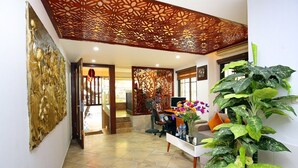 A modern interior with a reception desk, a decorative wall, and a staircase leading to another level. - Sumitomo 2 - 12 Dao Tan (Hanoi)