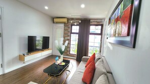 Apartament Deluxe, vistes a la ciutat | Sala d'estar | Televisor de 55 polzades amb canals per cable i llar de foc