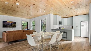 A modern kitchen with white cabinets and a stainless steel refrigerator. - 5 Cabins in GBurg | Sleeps 16 | Firepit & Games (Gatlinburg)