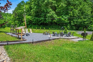 Een park met fitnessapparatuur, picknicktafels en een houten constructie.
