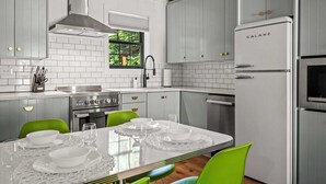 Een moderne keuken met witte kasten, een roestvrijstalen fornuis en een Galanz koelkast.