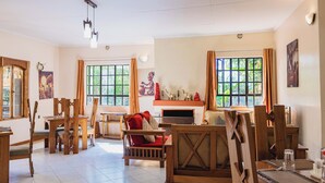 Ein geräumiges Wohnzimmer mit Holzmöbeln, großen Fenstern und einem Kamin.