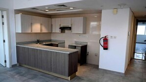 Una cocina moderna con armarios de madera clara, encimera de granito y estufa integrada.