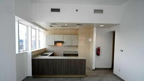 Una cocina moderna con una isla central, armarios integrados y un ventanal que proporciona luz natural.