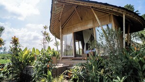 A wooden structure with a thatched roof, large glass windows, and surrounded by tropical plants. - Padi Bali Retreat (Payangan)