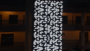 A hotel with a distinctive geometric facade and a prominent orange logo at the top. - Maurya Residency (Gingee)