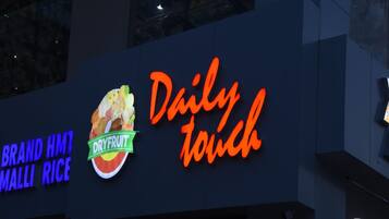 A sign for a food establishment with a neon sign reading "Daily Touch" and a logo for "DryFruit" with a bowl of fruit.