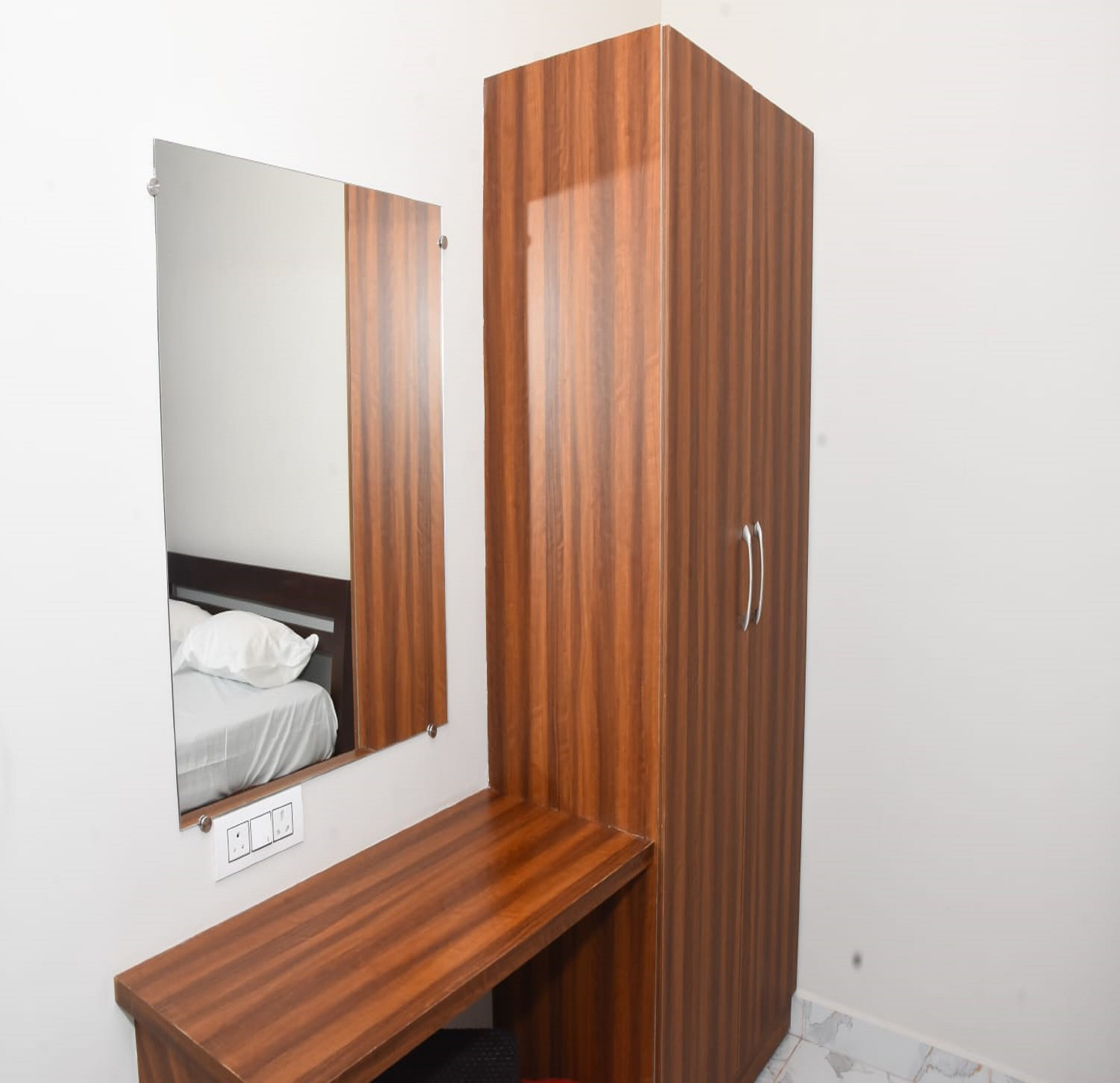 Een houten garderobe met spiegel en een bankje.