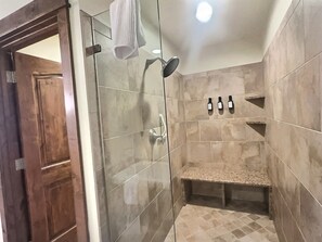 A shower with a glass door, a bench, and three bottles on the wall. - ✨ Seasons at BlueSky - Lux Penthouse 🏔️ Ski In/Ski Out 🎿 Spa 🧖‍♀️Resort Pool (Breckenridge)