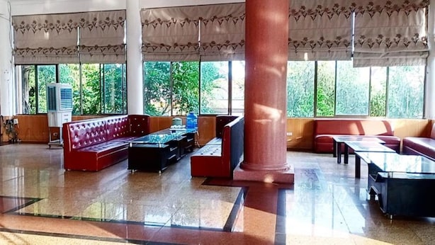 A spacious lobby with a red sofa, a glass coffee table, and a large pillar. - Viet Thai Hotel (Bac Hong Linh)