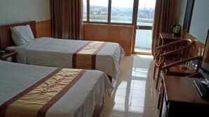 A hotel room with two beds, a desk, a chair, and a large window offering a city view. - Viet Thai Hotel (Bac Hong Linh)