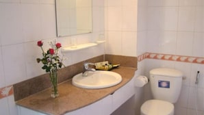 A bathroom with a white sink, a toilet, and a mirror above the sink. - Viet Thai Hotel (Bac Hong Linh)