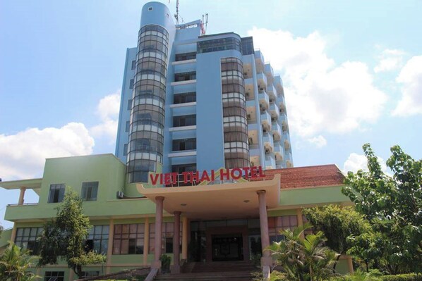 Un immeuble à plusieurs étages, avec une enseigne indiquant « HÔTEL VIET THAI » à l’entrée.