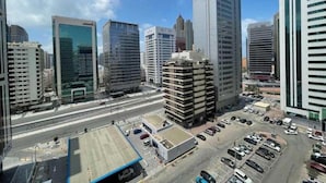 Une vue urbaine avec des immeubles modernes de grande hauteur, un parking et un ciel dégagé.