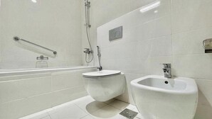 Une salle de bain moderne équipée d’une baignoire, de toilettes et d’un bidet.
