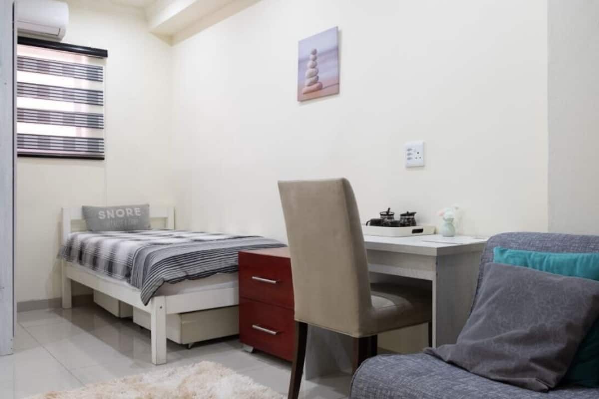 Une chambre à coucher avec un lit, un bureau, une chaise et un canapé.