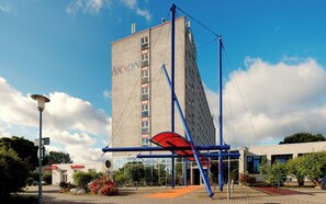 Un edificio de hotel alto con una estructura destacada de color rojo y azul en primer plano.