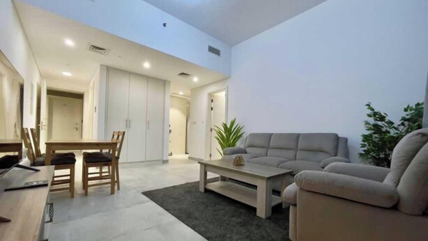 Un salon moderne avec un canapé, une table basse et un coin repas.
