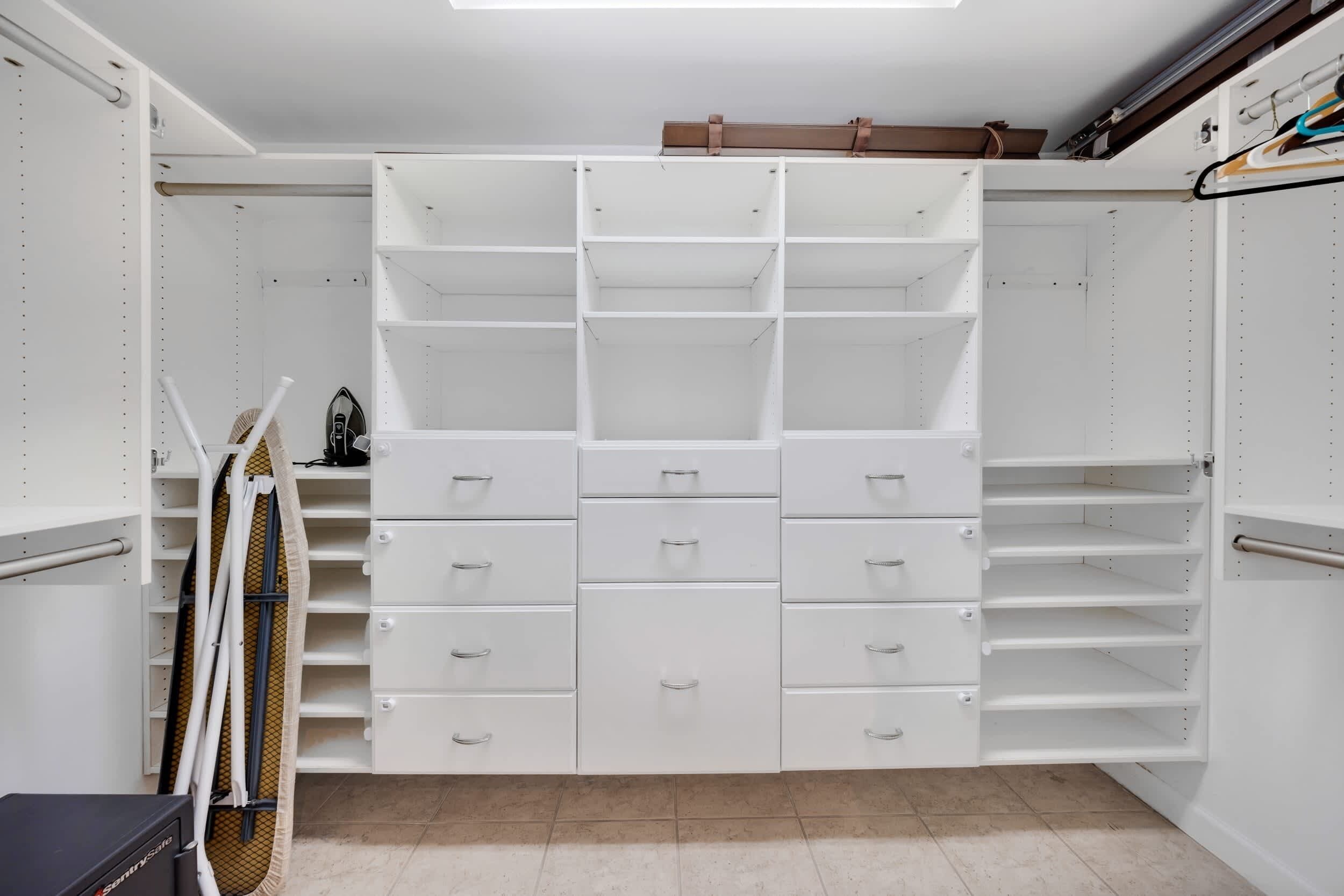 A walk-in closet with open shelving, drawers, and hanging space.