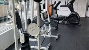 Un gimnasio con equipo de ejercicio, una cinta de correr y una ventana que ofrece vistas al exterior.