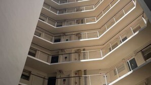 Un edificio de varios niveles con un atrio central y balcones en cada planta.