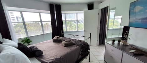 Un dormitorio con una cama, un tocador, un espejo y un ventilador de techo.