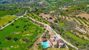 A rural landscape with a swimming pool, a road, and scattered buildings. - Villa River View in Peristerona (Peristerona)