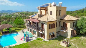 A two-story house with a swimming pool, a covered patio, and a view of the surrounding landscape. - Villa River View in Peristerona (Peristerona)