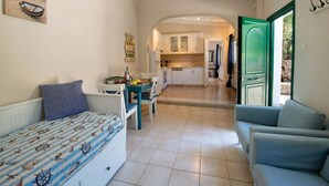 Un espace de vie compact comprenant un lit, un canapé, un coin repas et une cuisine.