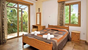 Un dormitorio con una cama de madera, una mesita de noche, un espejo y una ventana con cortinas.