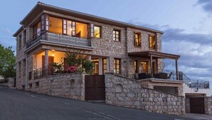 A two-story stone house with balconies, large windows, and a stone facade. - Villa Irene Palace in Peristerona (Peristerona)