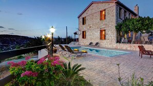 A stone building with a swimming pool, outdoor seating, and a view of the landscape. - Villa Irene Palace in Peristerona (Peristerona)