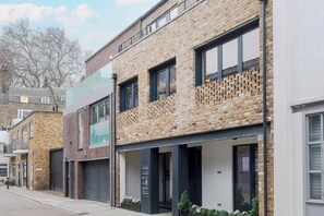 A modern building with a brick facade, large windows, and a flat roof.