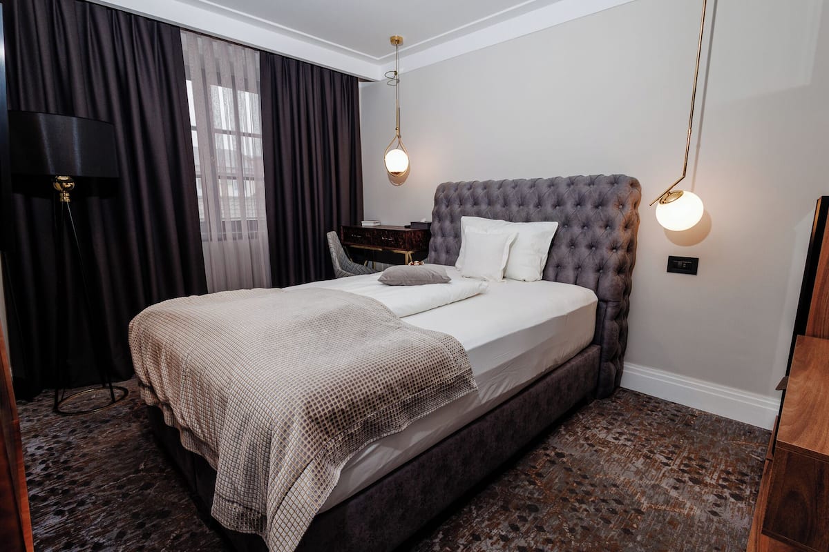 Una habitación de hotel con una cama grande, un escritorio y una silla.