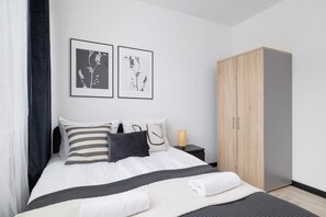 Un dormitorio moderno con cama, mesita de noche y armario.