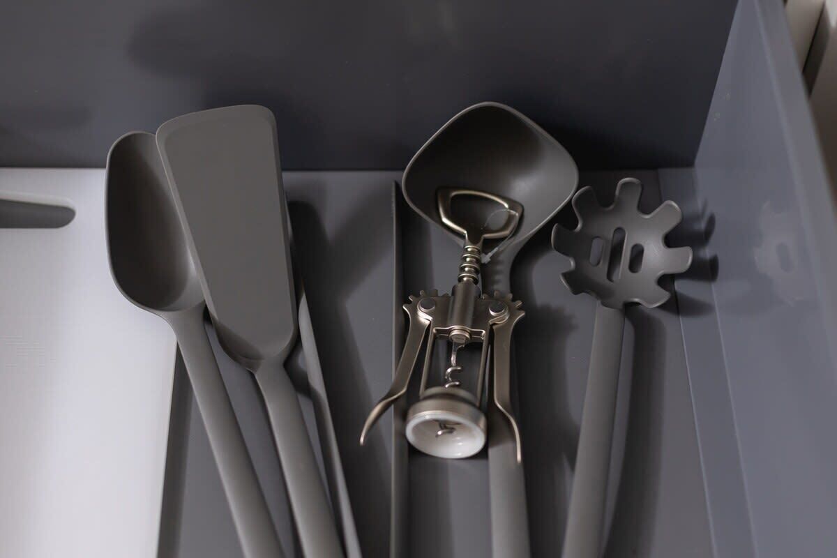 Un juego de utensilios de cocina que incluye una espátula, una cuchara para servir y un utensilio con mango tipo engranaje.