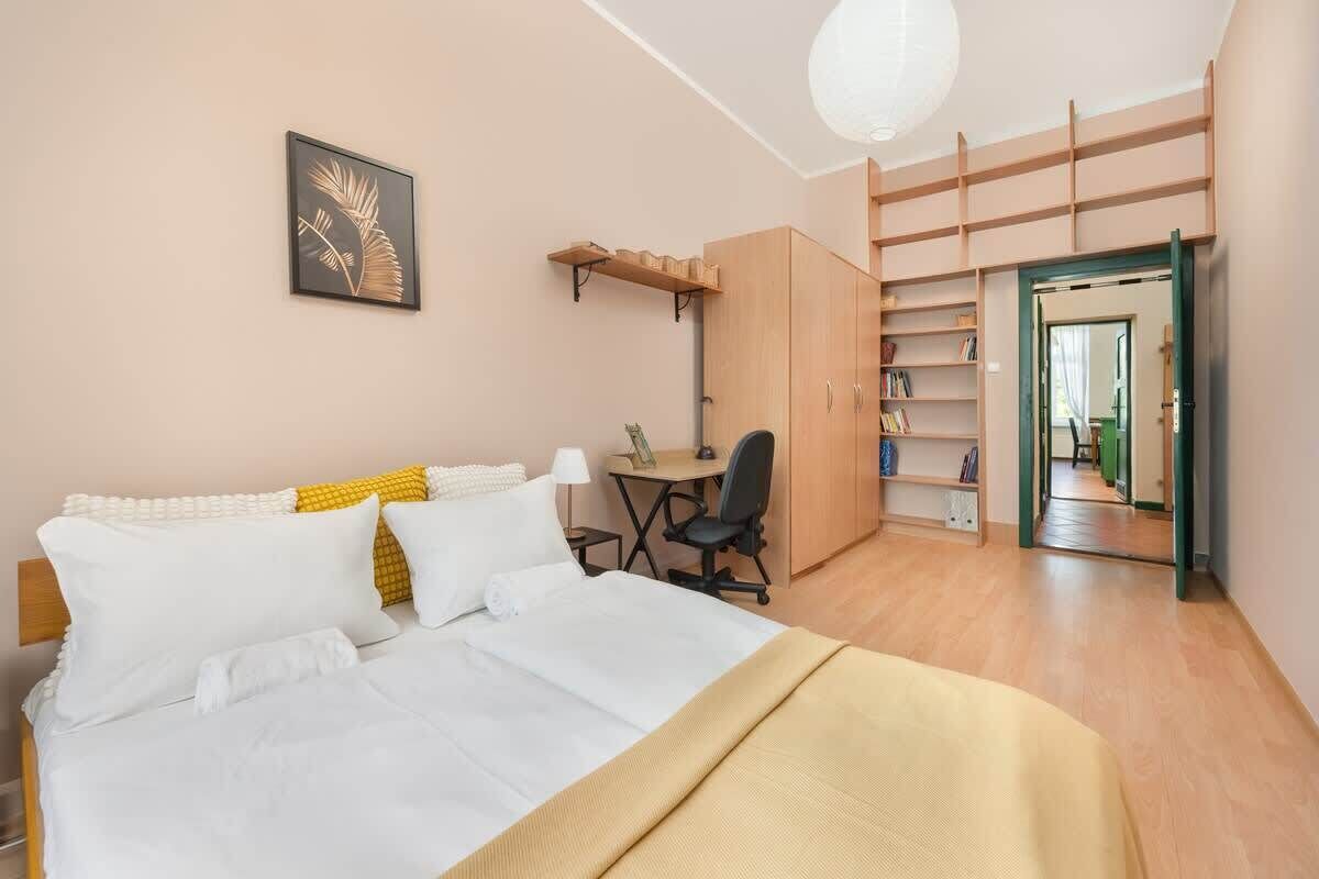 A bedroom with a bed, a desk, and a wardrobe.