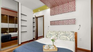 Ein Schlafzimmer mit einem Bett, einem Nachttisch, einem Kleiderschrank und einem Spiegel.