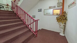 A staircase with red railings leading to a landing. - OYO 90999 DG HOTEL (Sungai Petani)