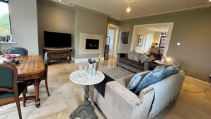 Una sala de estar con mesa de comedor, sofá, televisor y chimenea.