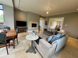 A living room with a dining table, sofa, TV, and a fireplace.