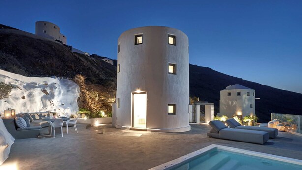 A modern villa with a cylindrical tower, a pool, and outdoor seating. - Windmill superior with private plunge pool
 (FC2M+X3 Imerovigli, Greece)