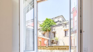 A room with a large open window, a white folding chair, and wooden flooring. - Terrazza Spaccanapoli By Napoliapartments (Naples)