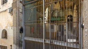 A large metal gate with a decorative arch and a metal fence. - Terrazza Spaccanapoli By Napoliapartments (Naples)