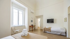 A hotel room with a bed, a desk, a chair, a TV, and a window. - Terrazza Spaccanapoli By Napoliapartments (Naples)